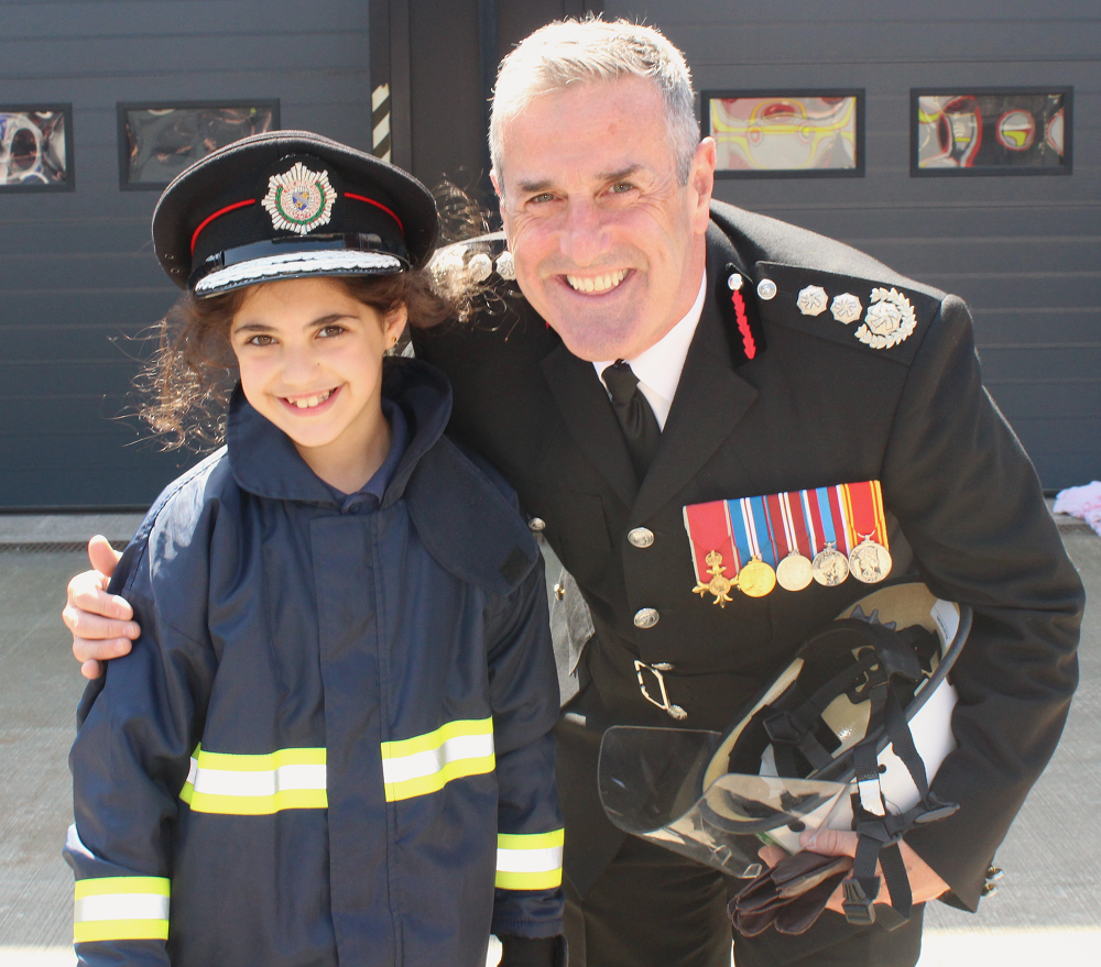 Young girl in fire uniform with Chief Fire Officer Phil Garrigan