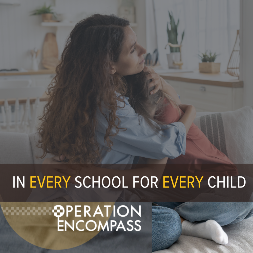 In every school for every child - Operation Encompass. Woman hugging a child