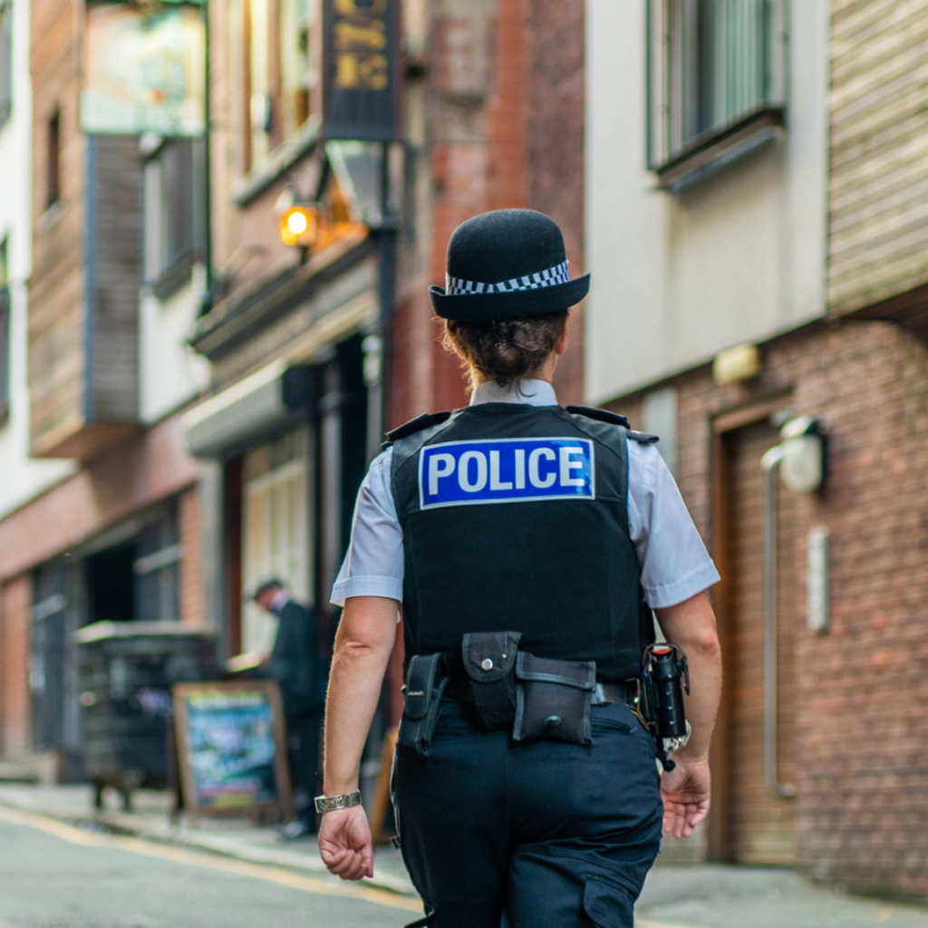 Back of a woman police officer walking up the street