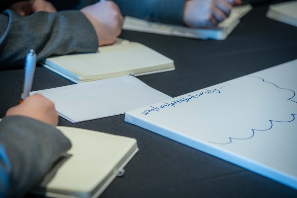 Young person is writing poetry in a book with a pen in hand
