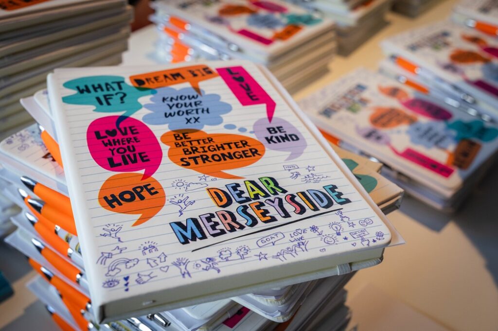 A stack of colourful books with one reading Dear Merseyside on top