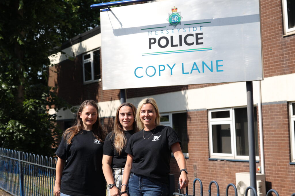 Custody Navigator team standing next to a sign for Copy Lane Police Station